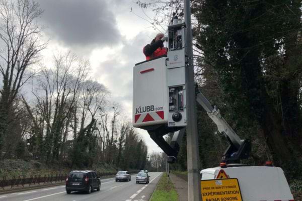 Technicien utilisant une nacelle pour installer un radar sur un poteau.