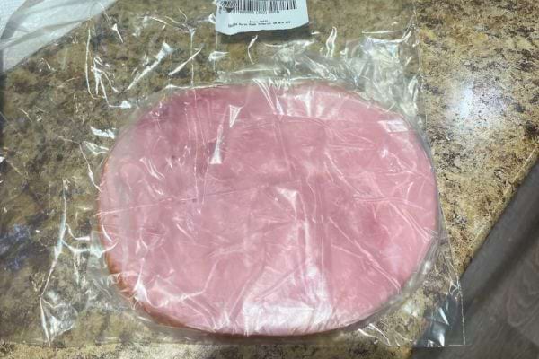 Jambon sous plastique sur plan de travail.