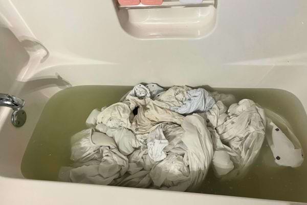 Linge trempé dans une baignoire remplie d'eau.