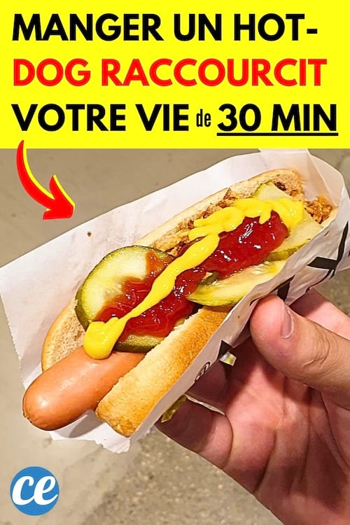 Un hot-dog avec du ketchup et de la moutarde qui est mangé par une personne