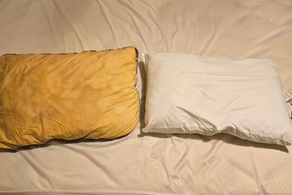 Comparaison d'un oreiller jauni à côté d'un oreiller blanc.
