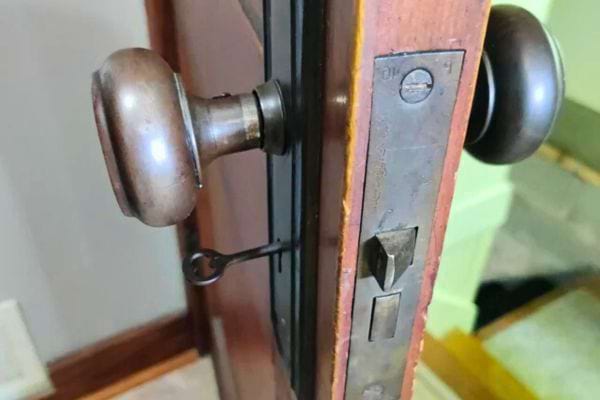 Détail d'une poignée vintage sur une porte en bois.