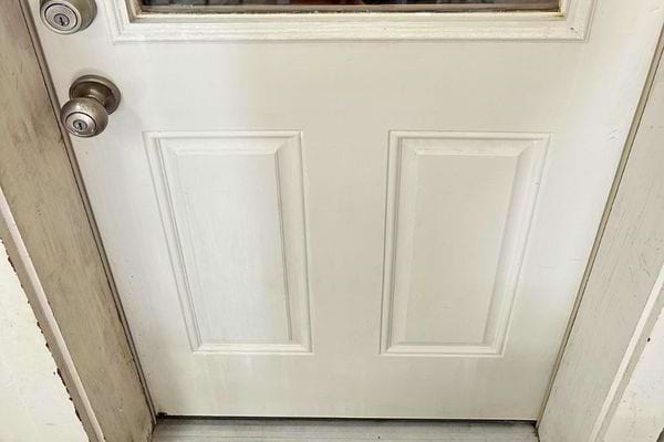 Une porte blanche avec des signes d'usure.