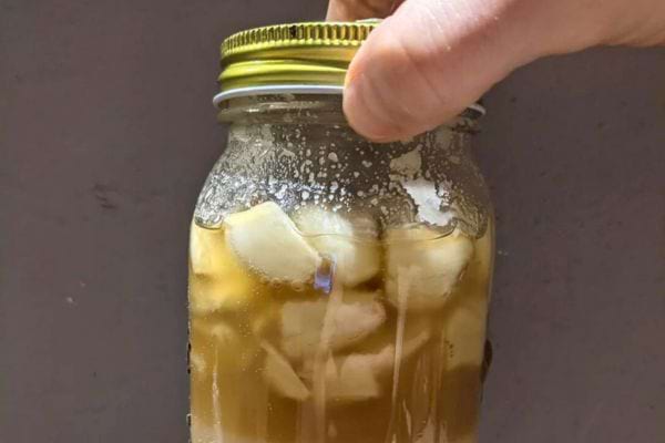 Pot de miel avec des morceaux d'ail, miel cristallisé.