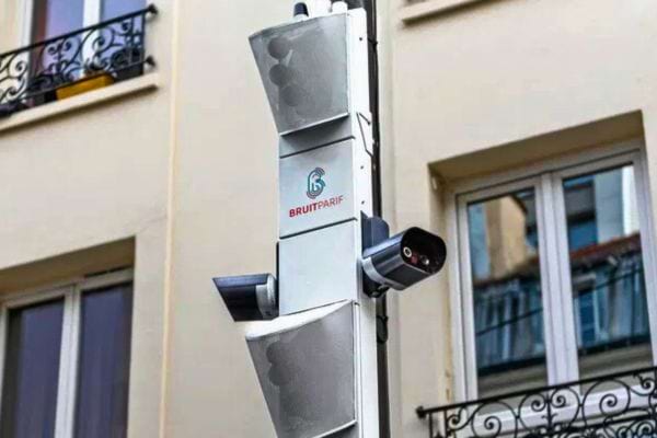 Radar de surveillance urbain monté sur un pôle devant un bâtiment résidentiel