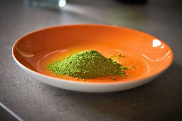 Assiette orange contenant de la poudre de moringa.