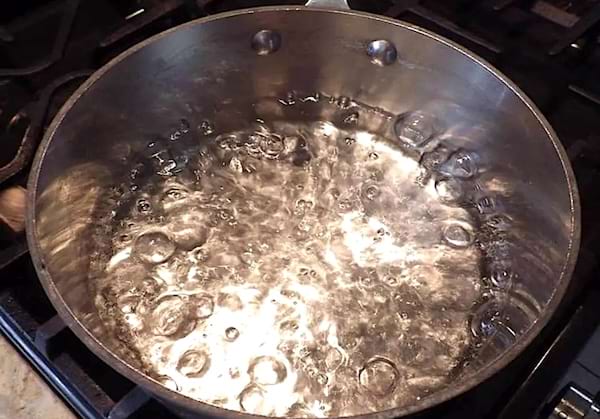 Une casserole d'eau et de sucre qui bout sur une gazinière. 