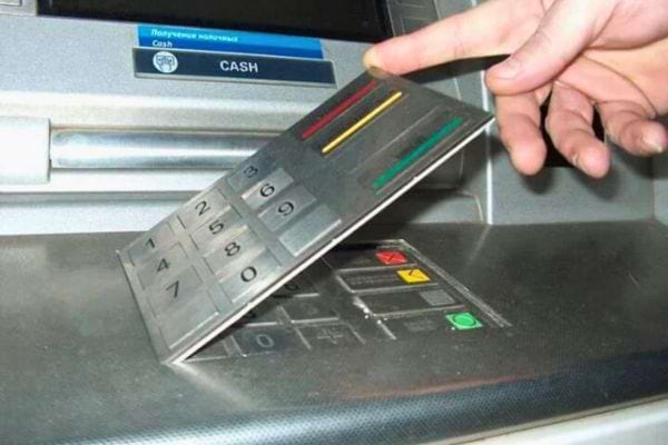 Main retirant un faux clavier d'un distributeur.