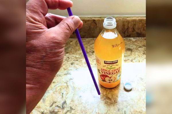 Un doigt sur une extrémité de paille pour créer une aspiration.