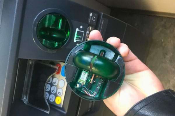 Main tenant un lecteur de carte démonté.