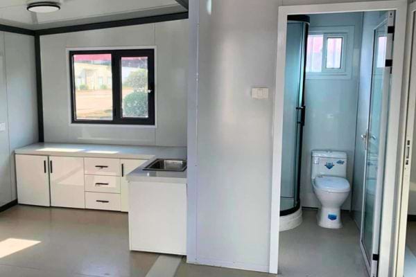 Intérieur épuré de tiny house avec cuisine et salle d'eau.