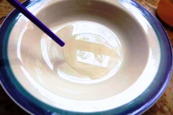 Une paille qui dépose la mère de vinaigre dans un bol.