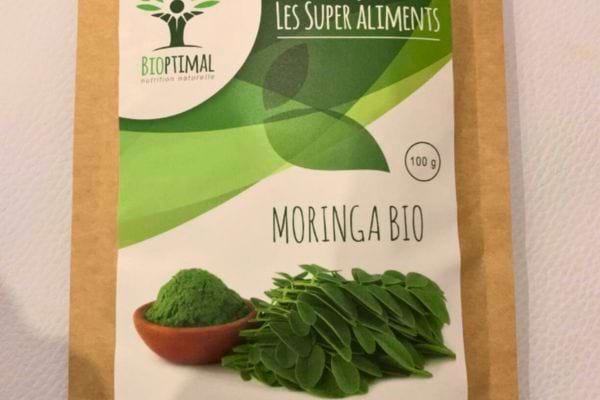 Packaging de moringa bio sur fond vert.
