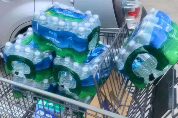 Packs d'eau minérale dans un caddie.
