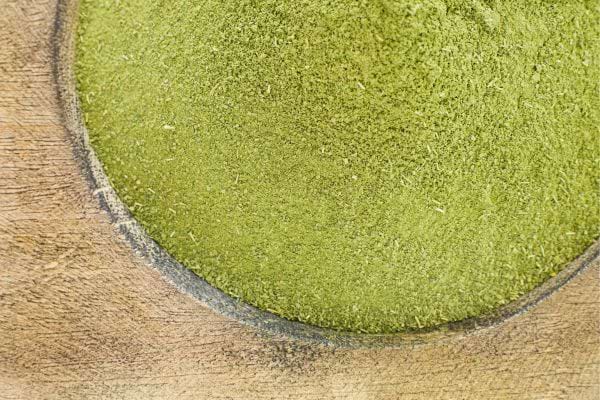 Poudre de moringa dans un récipient en bois