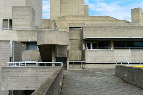 Un bâtiment brutaliste en béton avec des escaliers et des balustrades.