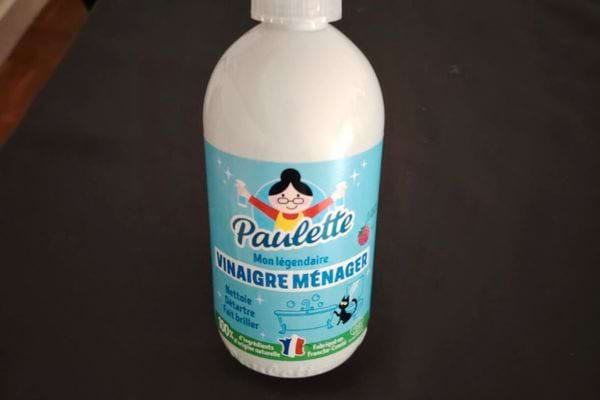 Bouteille de vinaigre ménager bleue sur un comptoir.