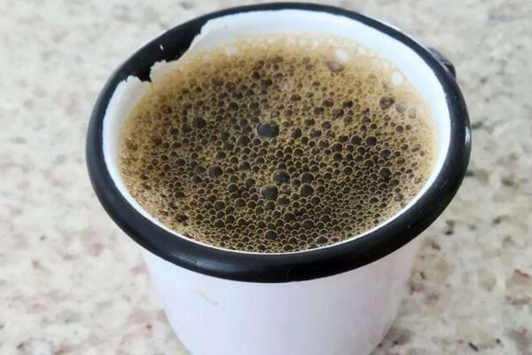 Une tasse de café vue de haut, montrant une mousse épaisse sur le dessus.