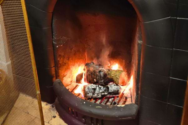 Feu de bois dans une cheminée ouverte.