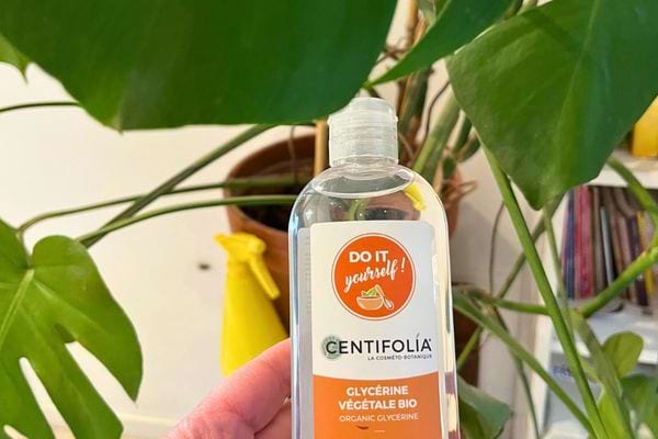 Glycérine Centifolia tenue à côté de plantes.