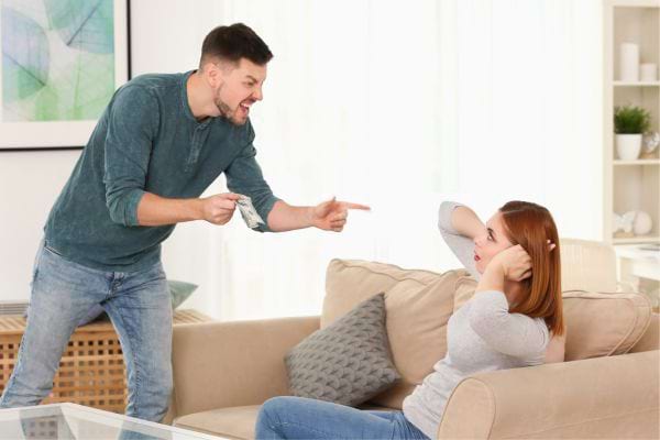 Un homme criant, femme se couvrant les oreilles.