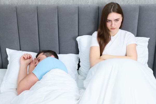 Un homme dort, femme frustrée.