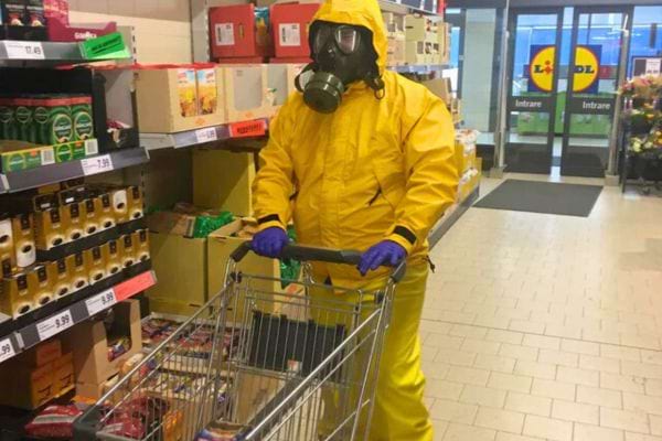 Personne en combinaison jaune et masque à gaz dans un Lidl.