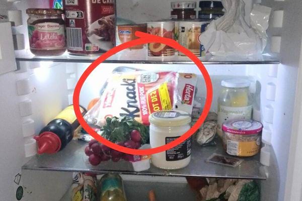 Paquet de saucisses Knacki au réfrigérateur parmi d'autres produits alimentaires.