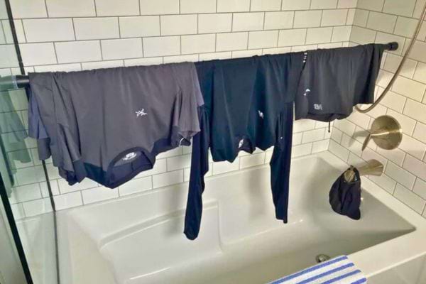 Linge noir suspendu sur une barre de douche.