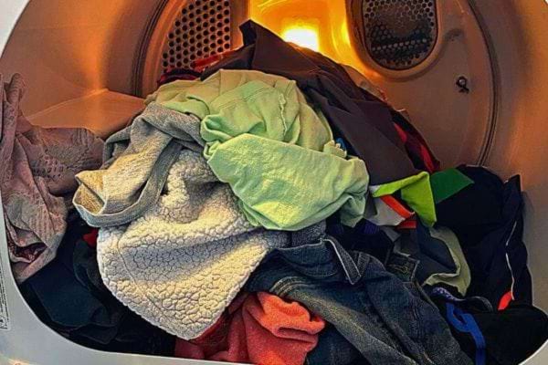 Vêtements froissés dans un sèche-linge allumé.
