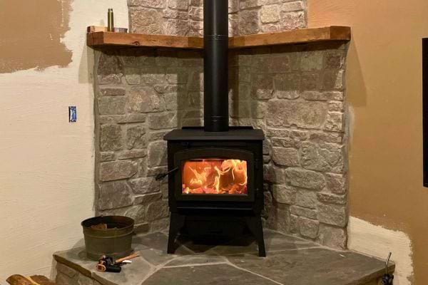 Poêle à bois sur un socle en pierre.