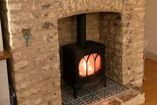 Poêle à bois sous une voûte en pierre.