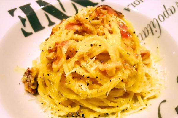 Spaghetti Carbonara, garnis de fromage et de poivre noir.