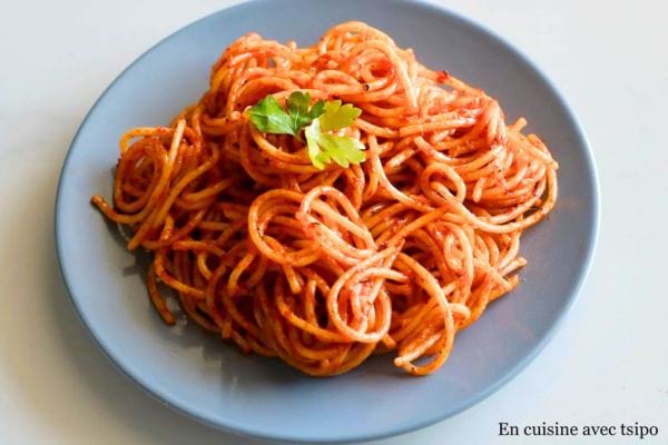 Spaghetti en sauce tomate garnis d'une feuille de basilic.