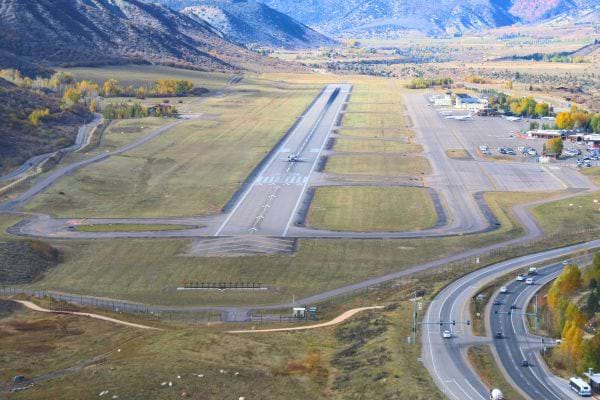 Aéroport dans une vallée avec route proche de la piste.