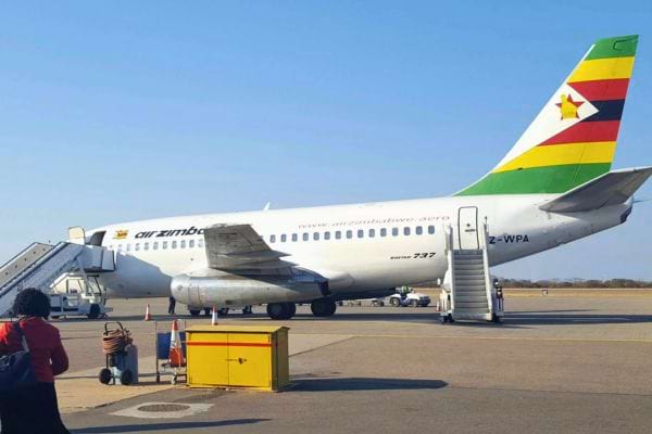 Avion Air Zimbabwe avec queue aux couleurs nationales, stationné à l’aéroport.