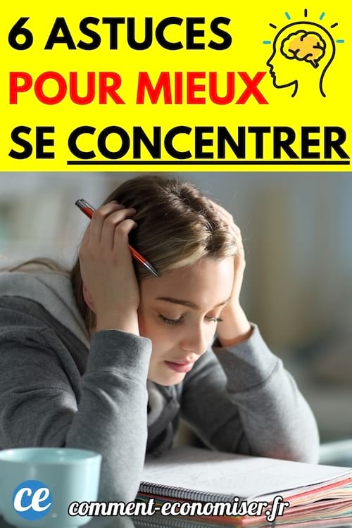 Femme concentrée appuyée sur un livre ouvert, tenant un crayon.