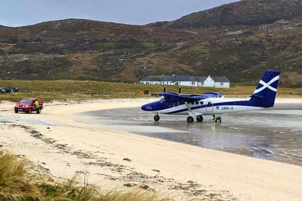 Petit avion atterrissant sur une plage en Écosse.