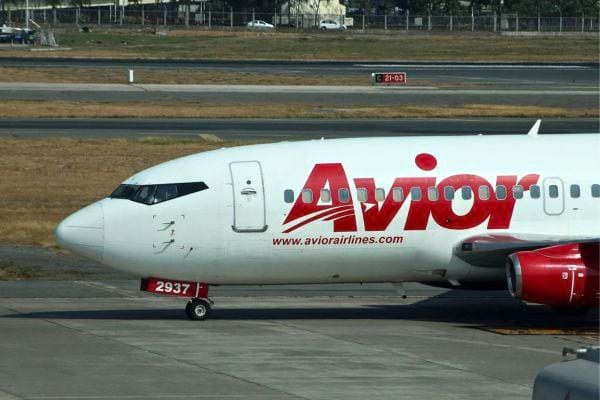 Avion Avior Airlines blanc et rouge roulant sur la piste.