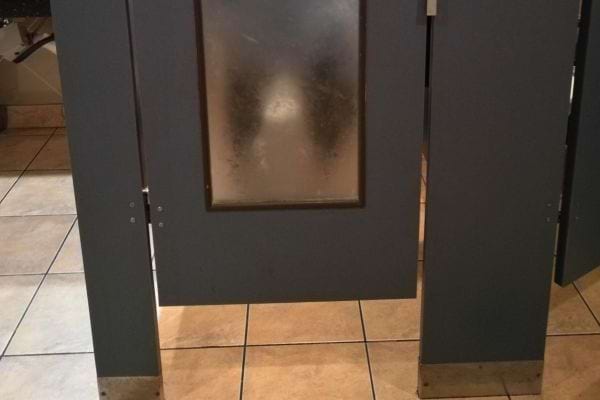 Porte opaque avec vitre floutée laissant deviner une silhouette.