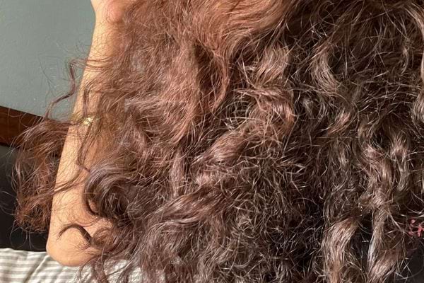 Cheveux bouclés et secs vus de dos.