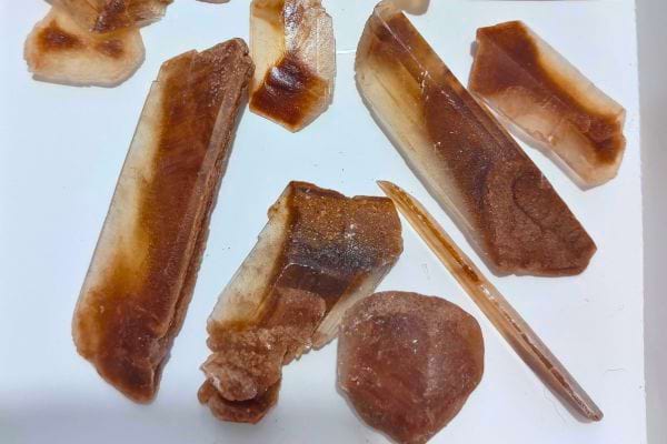 Fins cristaux marron-orangés sur fond blanc.