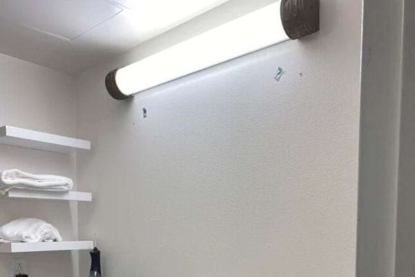 Étagère blanche avec serviettes sous lumière.