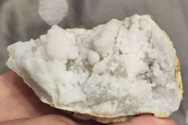 Cristaux blancs compacts en main.