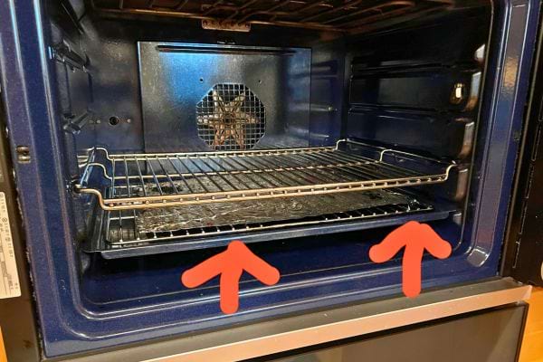 Un four avec une grille et un plat en bas.