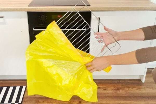 Une grille de four est insérée dans un grand sac jaune.