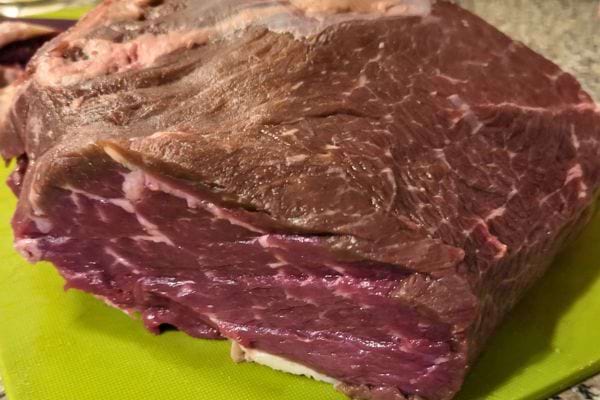 Un bloc de viande foncé et peu appétissant sur une planche.