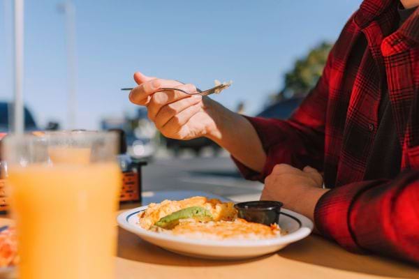 Homme dégustant un plat en terrasse.