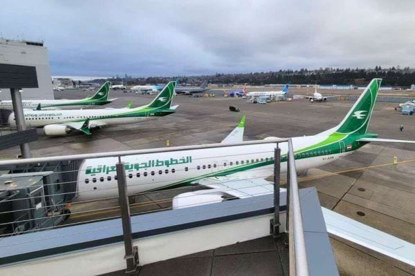 Plusieurs avions Iraqi Airways verts alignés à l’aéroport.
