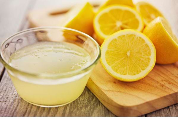 Citrons coupés et bol de jus de citron.